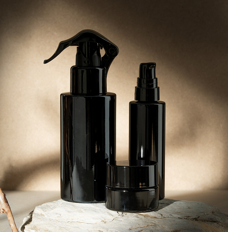 Elegant black/purple Miron glass bottles and jars for skincare and cosmetics, designed to protect and preserve product freshness and potency.